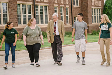 Dr. Gamble walking across campus with students