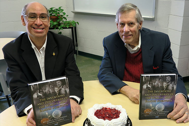 Drs. Manuel Varela and Michael Shaughnessy holding their recently-published book.