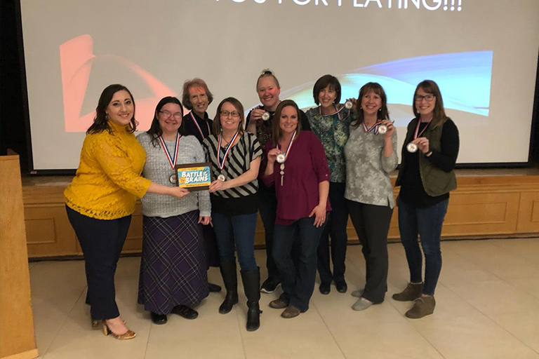 (L-R) MC, Tyleen Caffrey and the team: Regina Bouley Sweeten, Patrice Caldwell, Wendy Turner, Debra Koepp, Crystal Evaniuck, Edwina Gower, Cindy Gentry and Jennifer Smith.