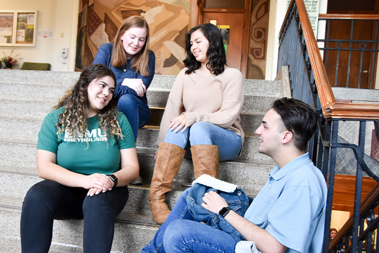 Students sitting on steps and talking to each other