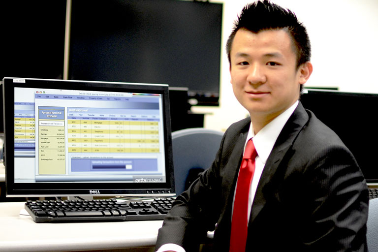 Man sitting near computer smiling at camera