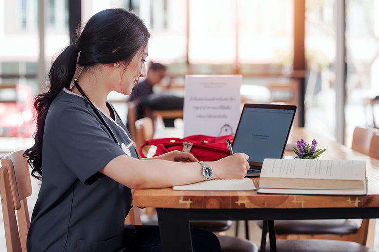 Bursing student studying with books and a laptop