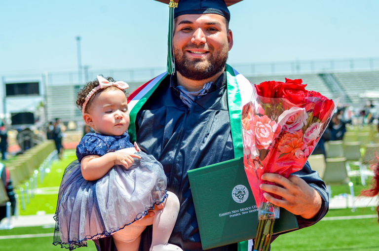 ENMU student holds daughter in graduation gown