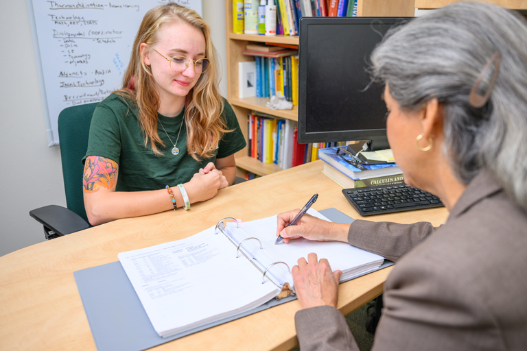 student speaks with advisor