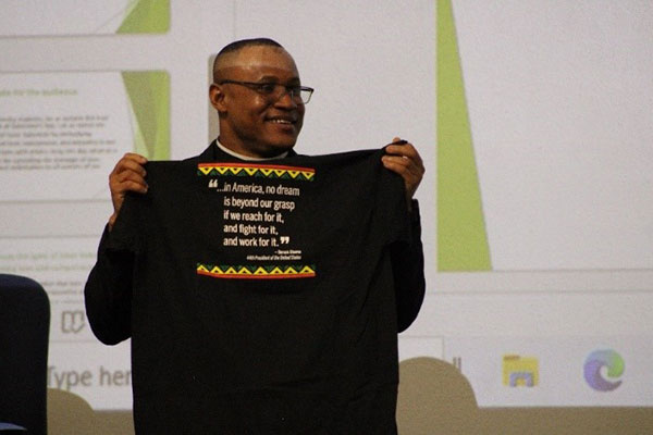 Man at AAA Conference holding AAA shirt